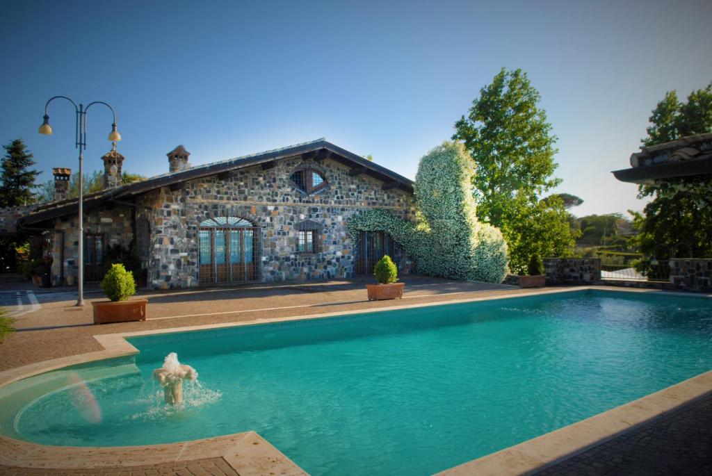 a swimming pool in front of a stone house at Resort Villa Domus Petra in Zagarolo
