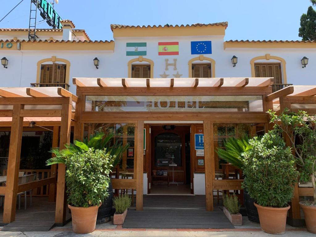 a building with a wooden entrance with potted plants at Hotel Antonio Conil in Conil de la Frontera