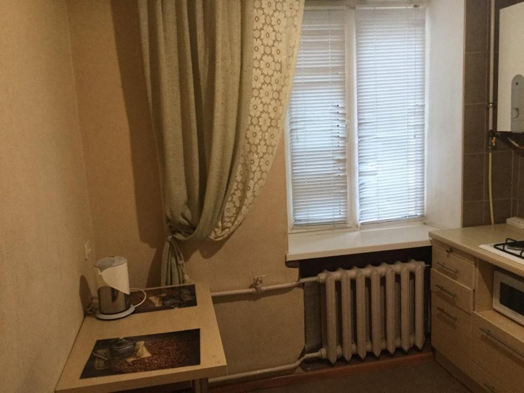 een kleine keuken met een radiator en een raam bij Квартира рядом с парком Б. Хмельницкого (центр) из первых рук in Chernihiv