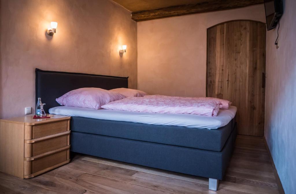 a bedroom with a bed with pink pillows on it at Heuhof-Breitau Gästezimmer in Sontra