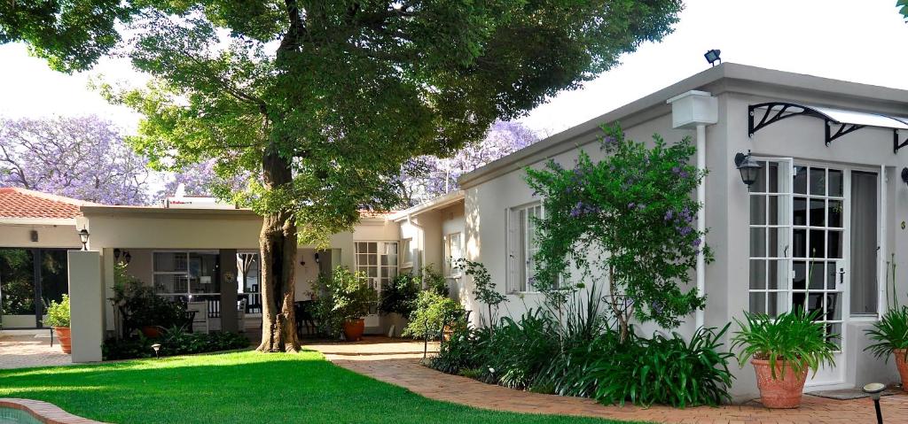 Johannesburg的住宿－Rosebank Lodge Guesthouse by Claires，前面有草坪的白色房子