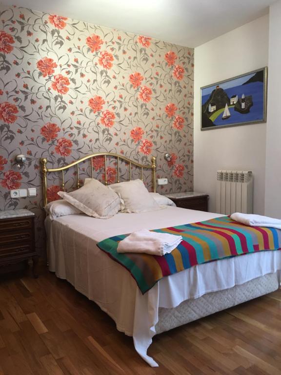 um quarto com uma cama com papel de parede floral em EL RINCÓN DE TORRENUEVA em Zaragoza