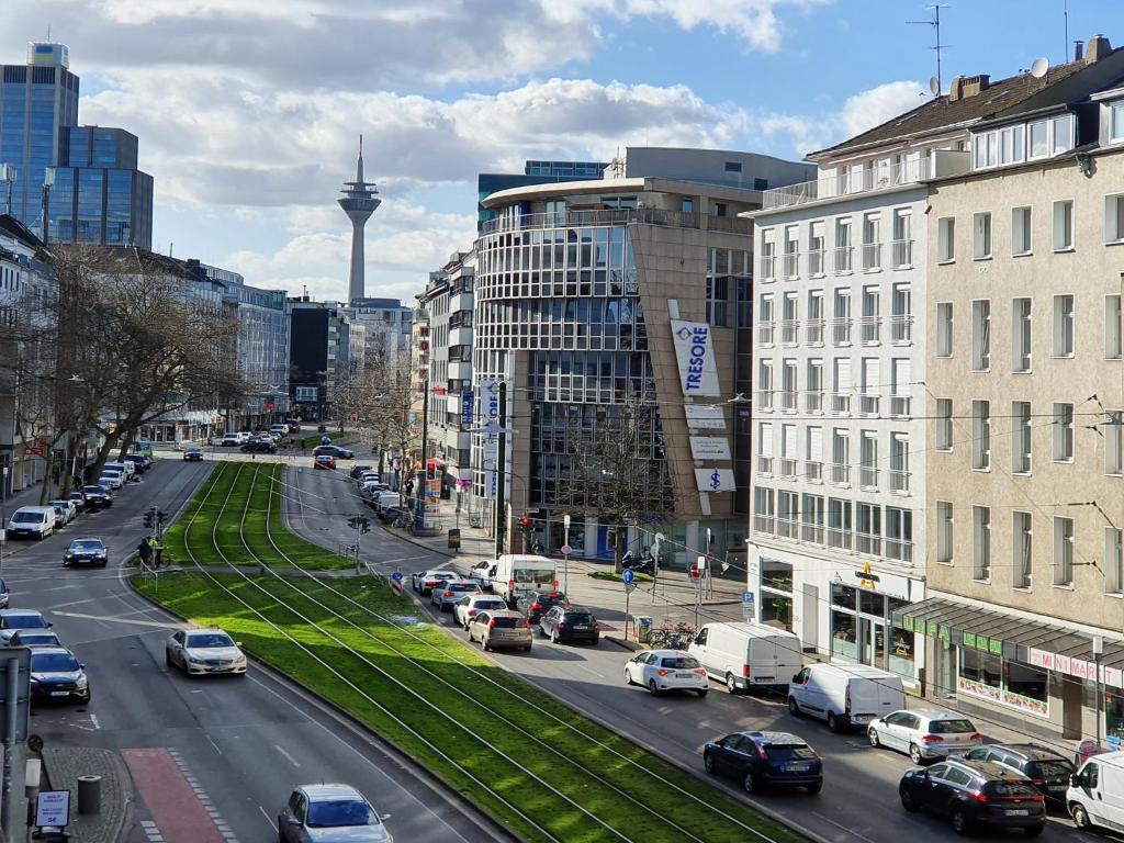una strada trafficata della città con auto e edifici parcheggiati di Graf-Adolflux a Dusseldorf