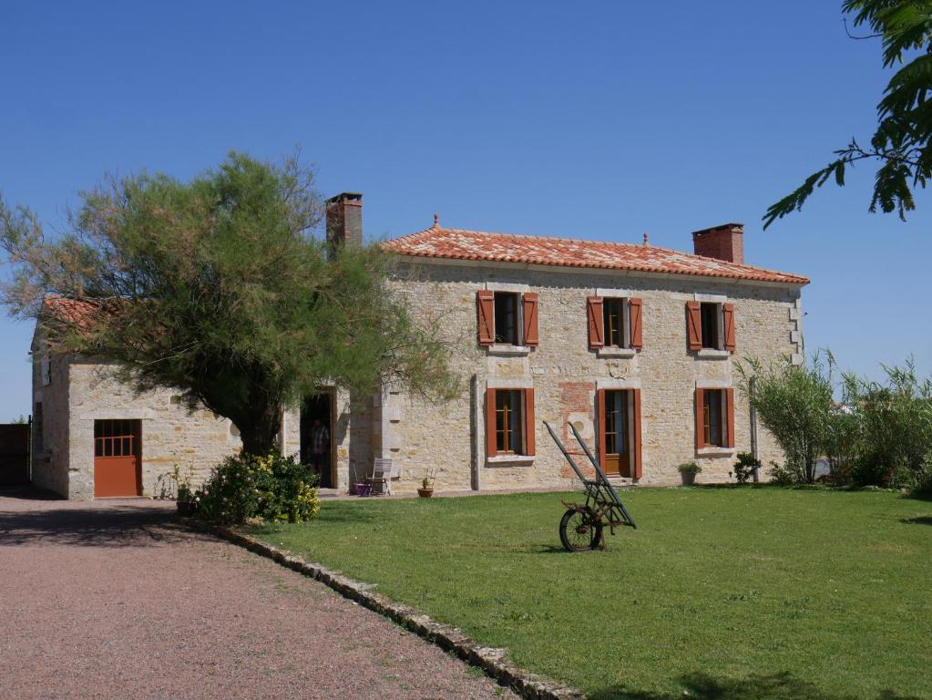 una vieja casa de piedra con una bicicleta delante en Le Tamaris Chambres d'hôtes, en Sainte-Hermine