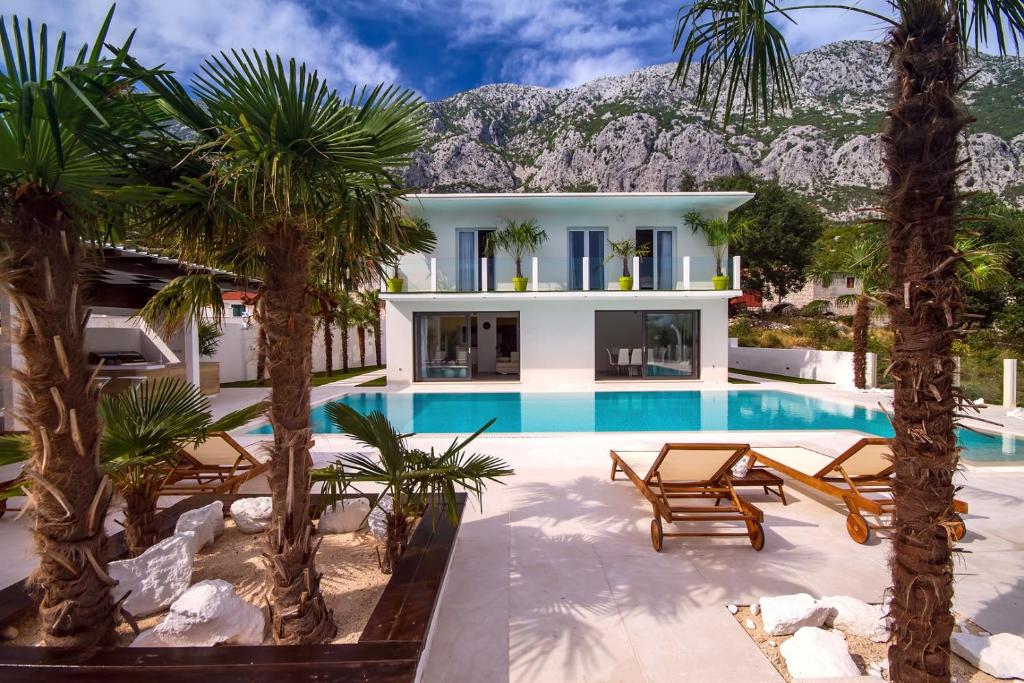 een villa met een zwembad en palmbomen bij Villa Caribic with 72sqm private pool, whirlpool, sauna, outdoor lounge area in Gata