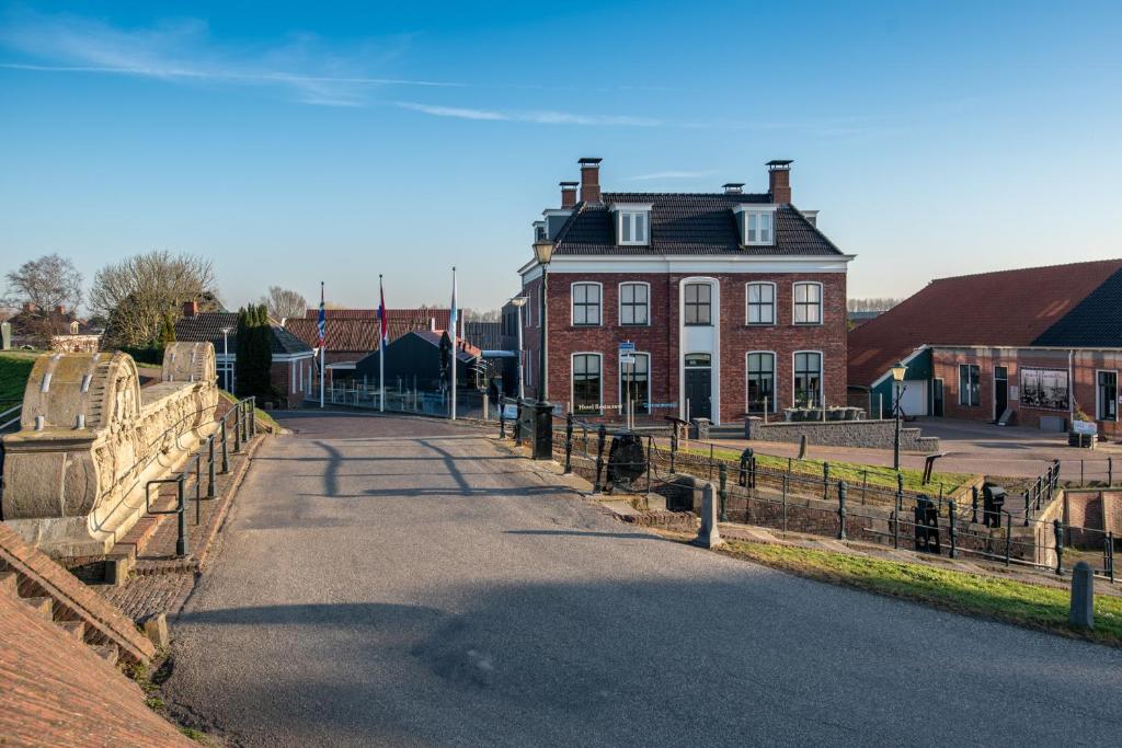 a house with a fence in front of a street at Hotel-Restaurant Termunterzijl in Termunterzijl