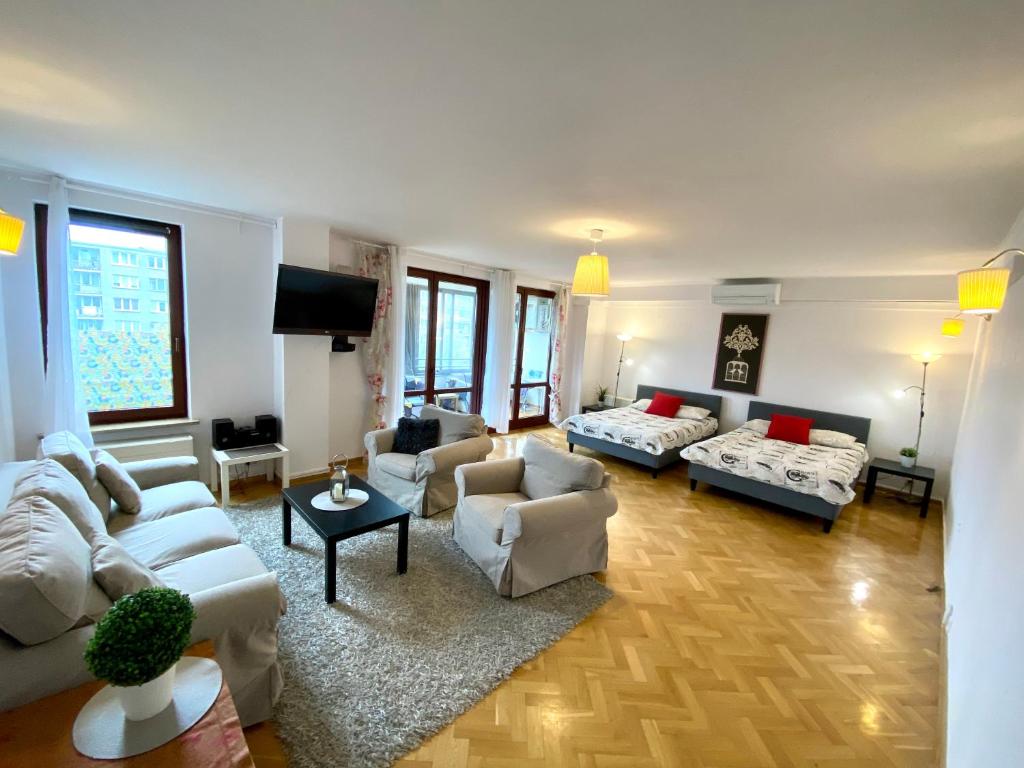 a large living room with couches and a tv at Center Warsaw - Apartmenty Jana Pawła II in Warsaw