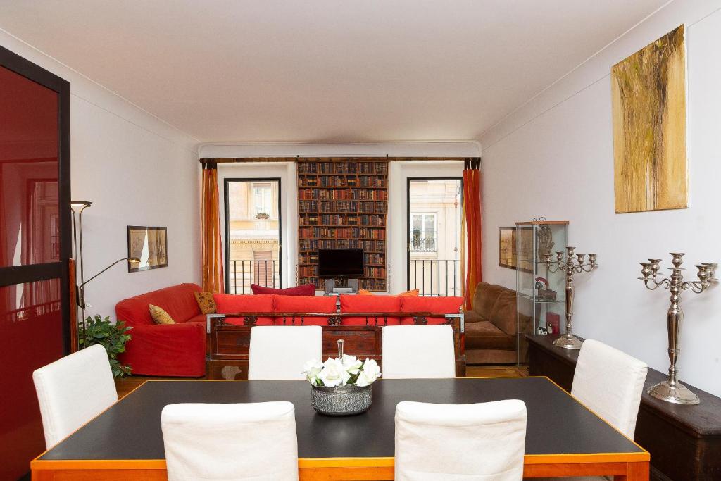 a living room with a table and a red couch at Amazing New Apartment Jewish Ghetto in Rome