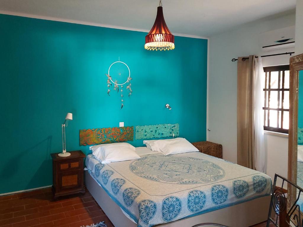 1 dormitorio con 1 cama con pared azul en CASA 19 en Albufeira