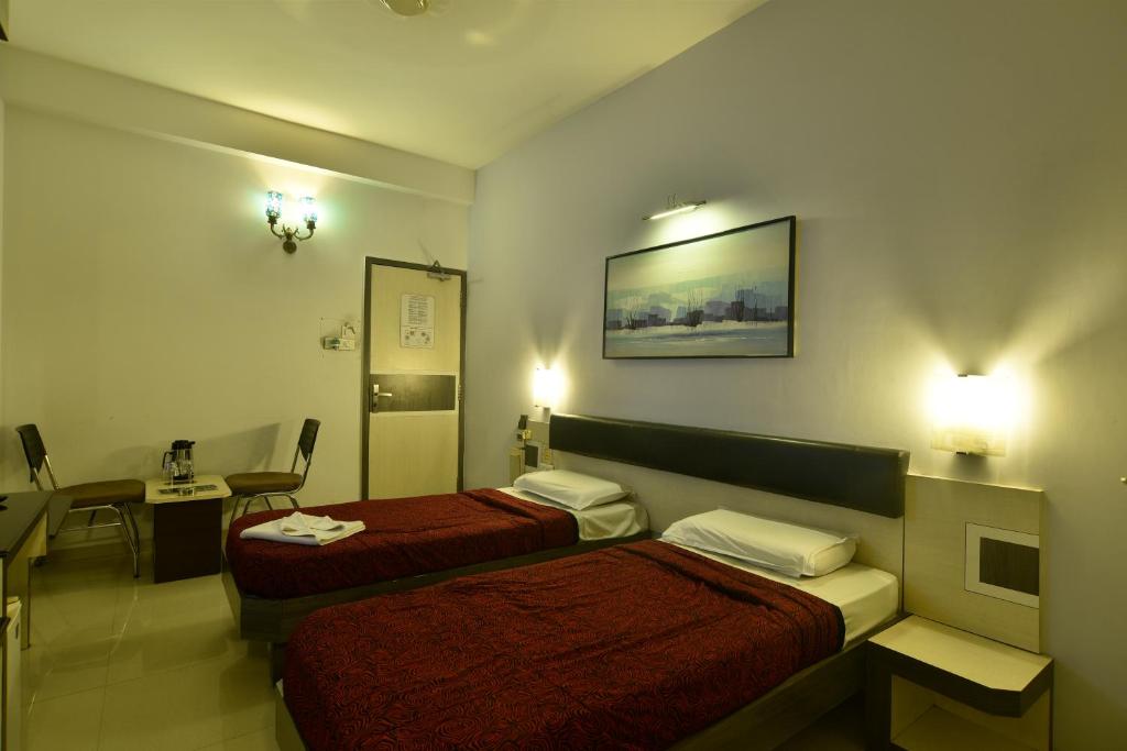Postel nebo postele na pokoji v ubytování Panchavati Elite Inn