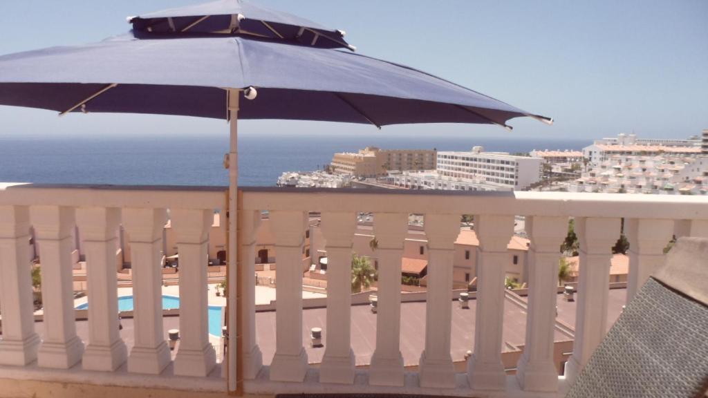 a blue umbrella sitting on top of a balcony at Arcoiris in Callao Salvaje