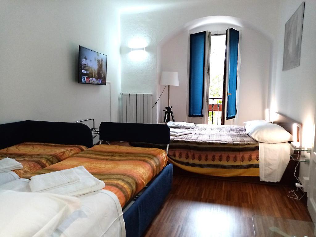 a hotel room with three beds and a window at Room Inn in Milan