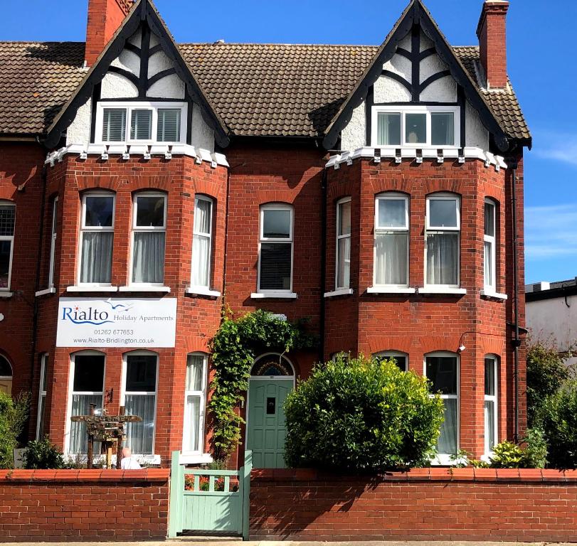 a red brick house with a green door at Rialto Holiday Apartments in Bridlington