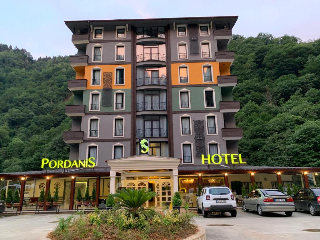 a hotel with cars parked in a parking lot at PORDANİS HOTEL in Çamlıhemşin