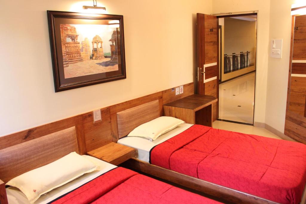 Postel nebo postele na pokoji v ubytování Panchavati Elite Inn