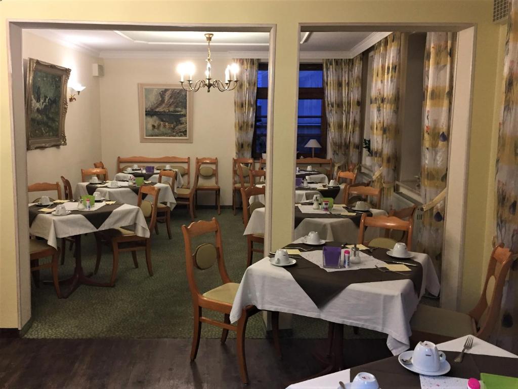 un comedor con mesas y sillas blancas en Hotel Eberbacher Hof, en Biberach an der Riß