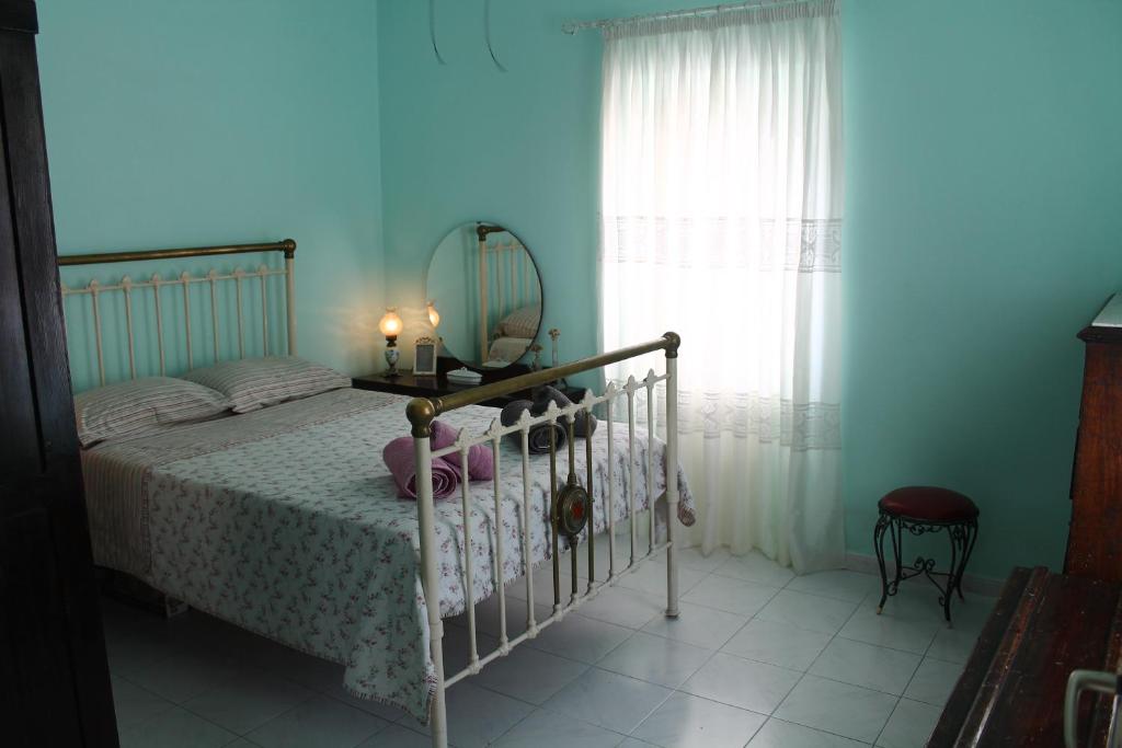 una camera da letto con un letto con uno specchio e una finestra di Nona's Guest House Corfu Βenitses a Benitses