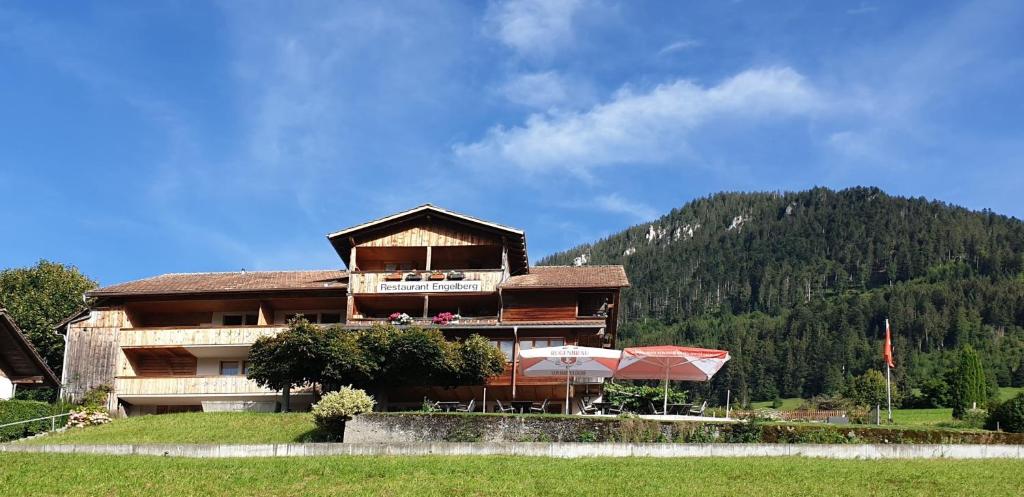 ein großes Gebäude mit einem Berg im Hintergrund in der Unterkunft Gasthof Engelberg in Scharnachtal 