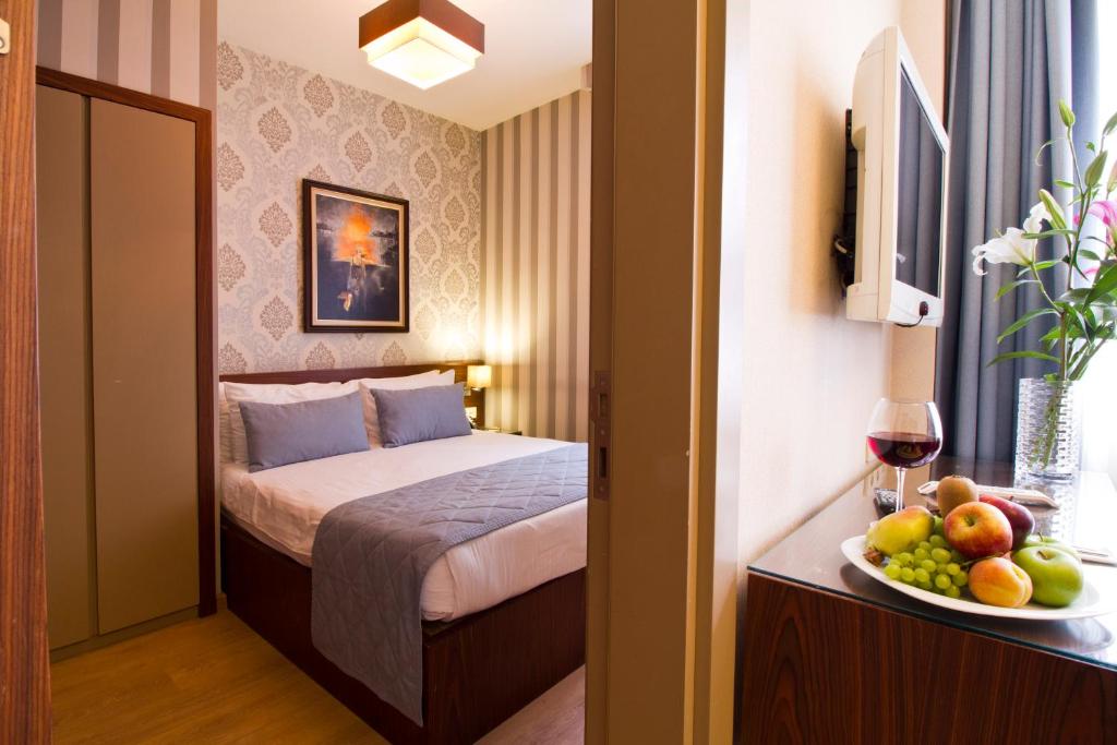 - une chambre d'hôtel avec un lit et une corbeille de fruits dans l'établissement Alba Hotel Taksim, à Istanbul