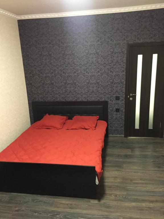 1 dormitorio con cama roja y manta roja en Отель Переулок средний 16, en Kropyvnytskyi