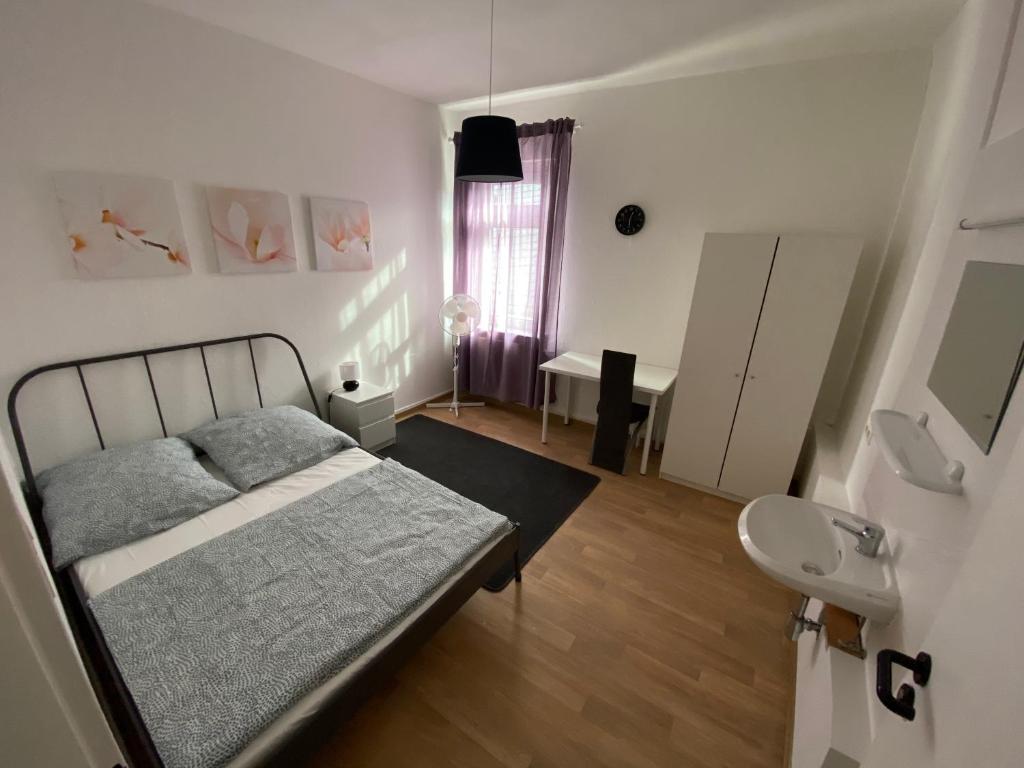 1 dormitorio con 1 cama y baño con lavamanos en Hotel am Schloss en Frankfurt