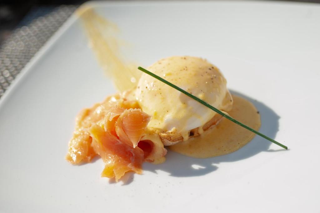 a white plate with a dessert with shrimp and ice cream at Vivid Blue Serenity Resort in Sveti Stefan