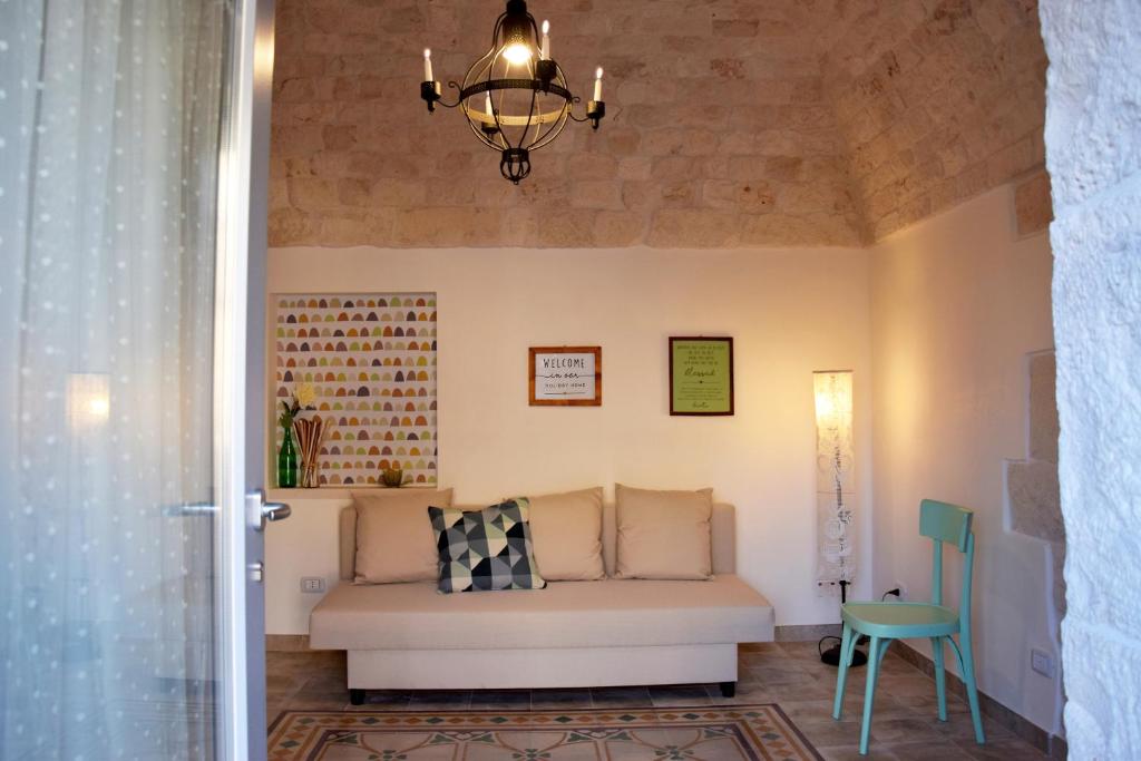 een woonkamer met een bank en een kroonluchter bij A volte in collina in Martina Franca