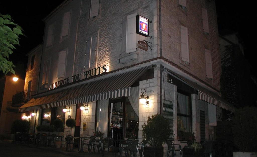 a building with a sign on the side of it at Auberge du Puits in Souillac