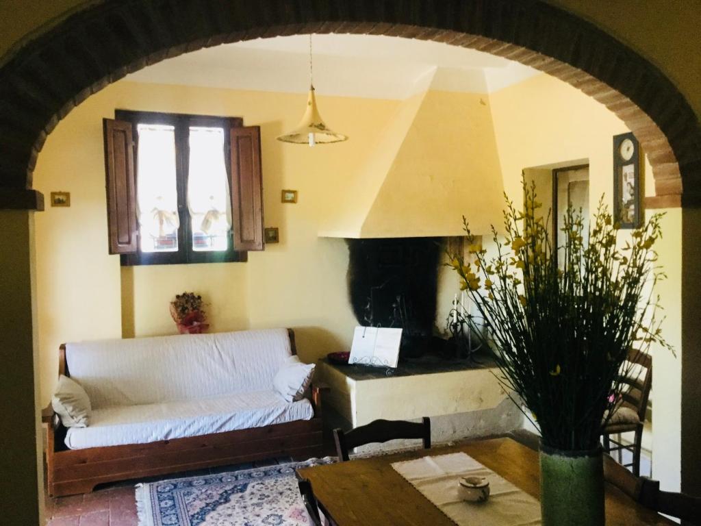 un salon avec un canapé et une cheminée dans l'établissement Agriturismo Podere Delle Querci, à Castiglion Fiorentino