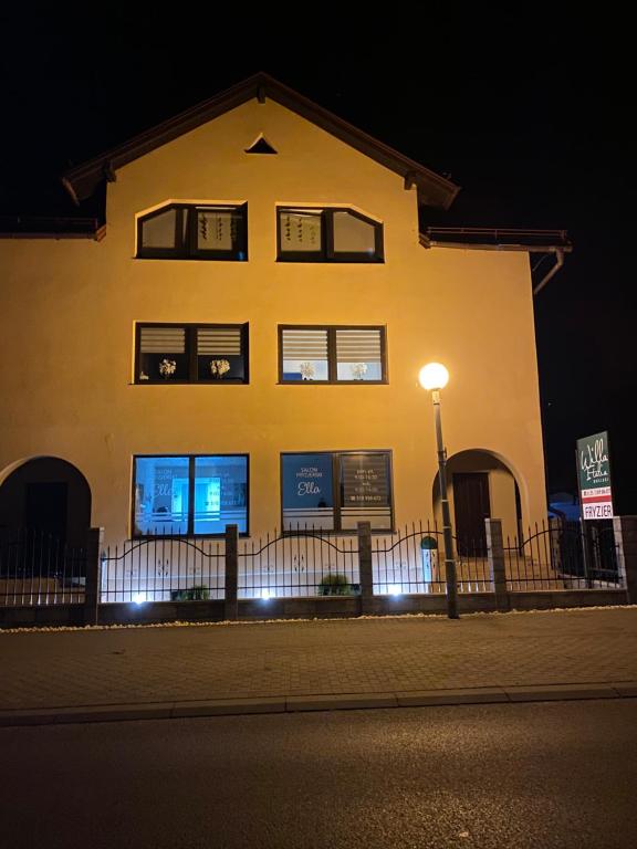 a yellow building with a street light in front of it at Willa Italia in Ustroń