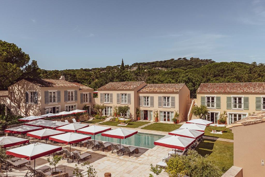 an aerial view of a mansion with a pool and umbrellas at Hotel Lou Pinet in Saint-Tropez
