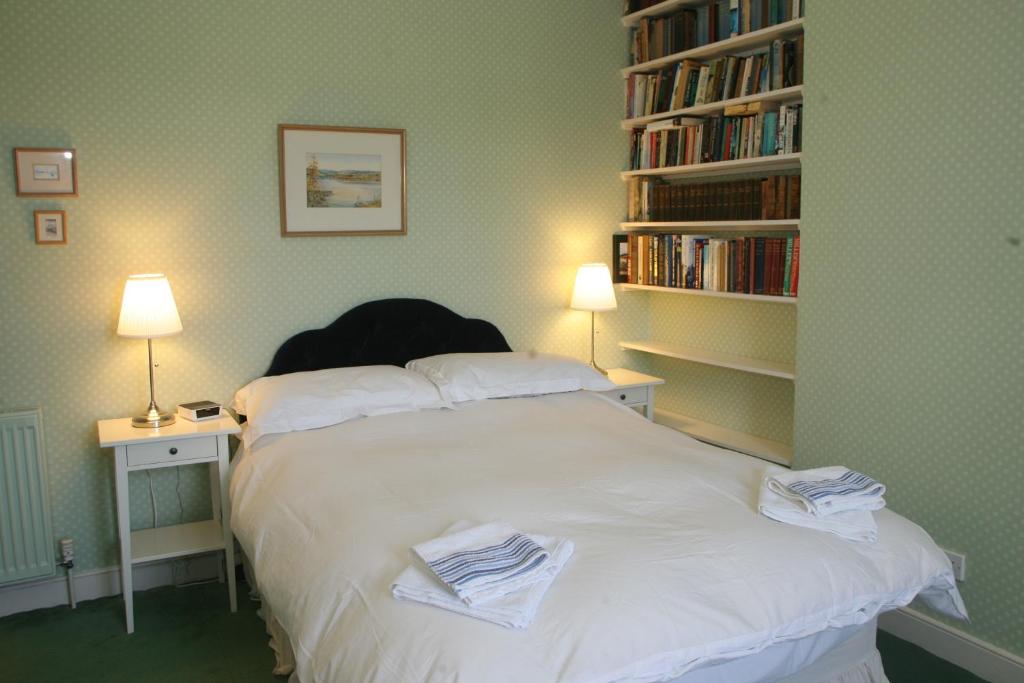 Kirklands House في ميلروز: غرفة نوم مع سرير أبيض مع رف كتاب