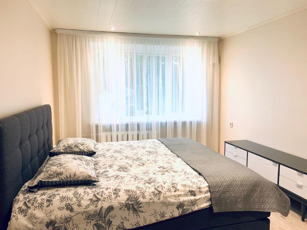 um quarto com uma cama e uma grande janela em Sepa Apartment em Valga