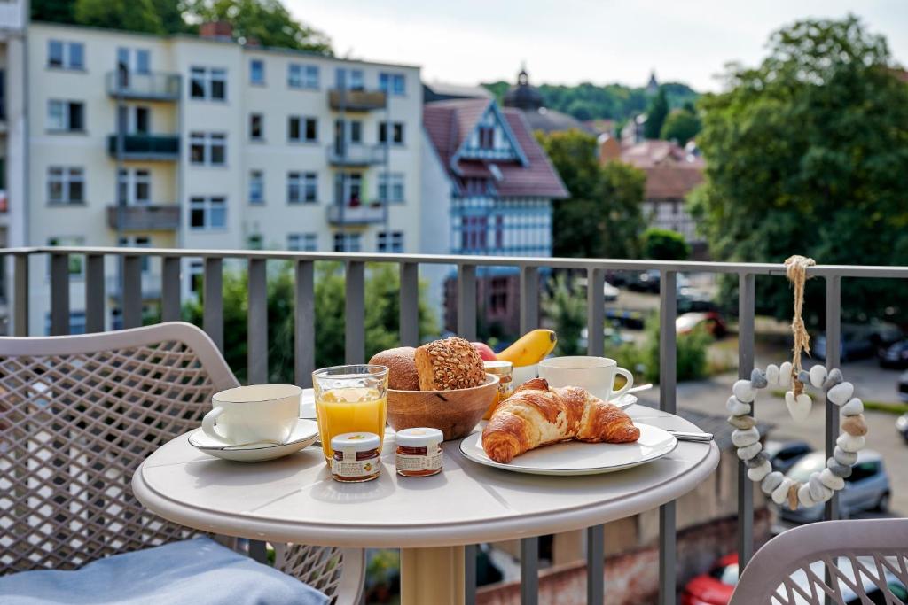 a table with a breakfast of croissants and orange juice at Suites MITTE - Aparthotel in Eisenach
