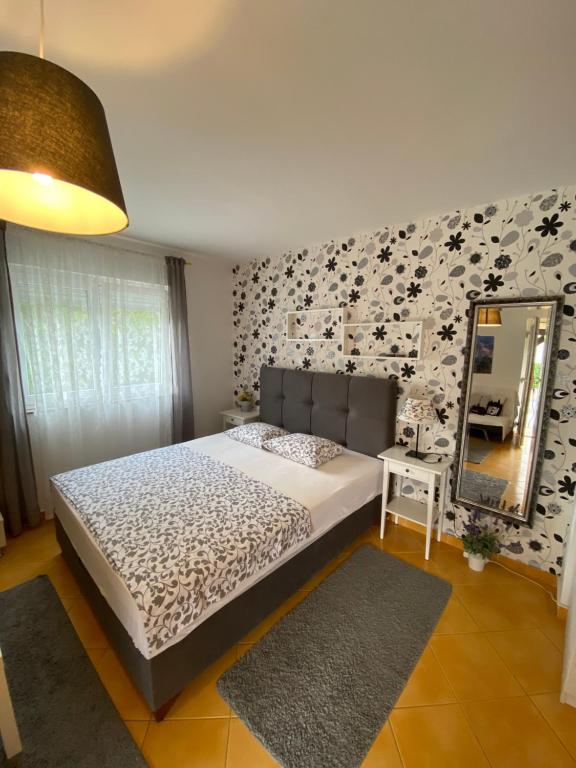 a bedroom with a bed and a mirror at Apartment Lara in Rab