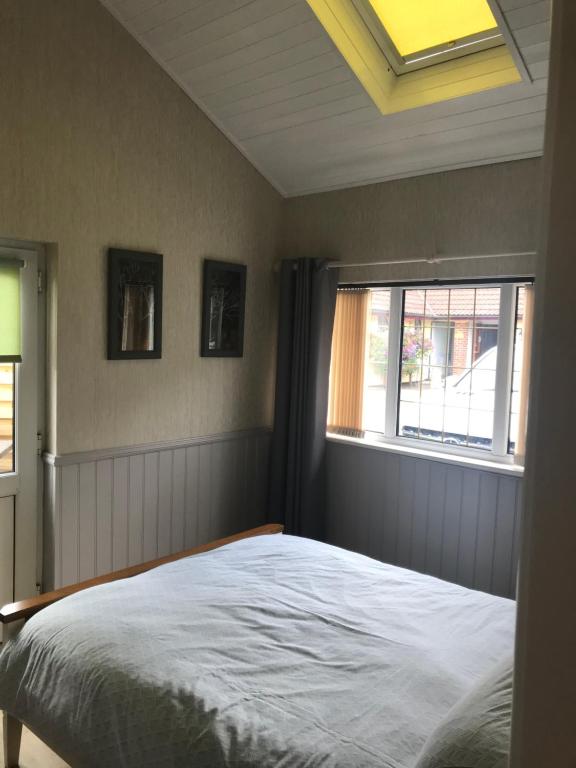 1 dormitorio con cama y ventana en The Annex Apartment is on Cheddar Bridge Apartments en Cheddar