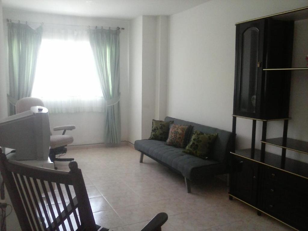 a living room with a couch and a tv at Apartamento para Vacaciones y Teletrabajo in Vecindario