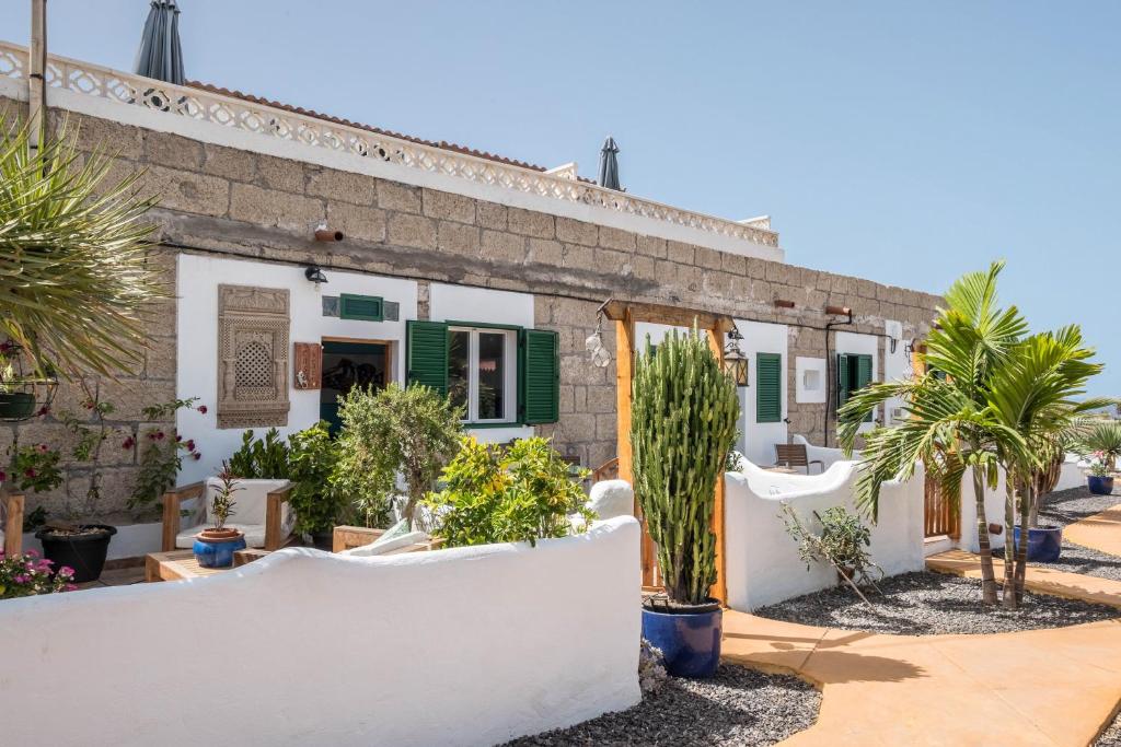 a house with white walls and palm trees in front of it at Casa Drago - Villa Perenquén in Guía de Isora