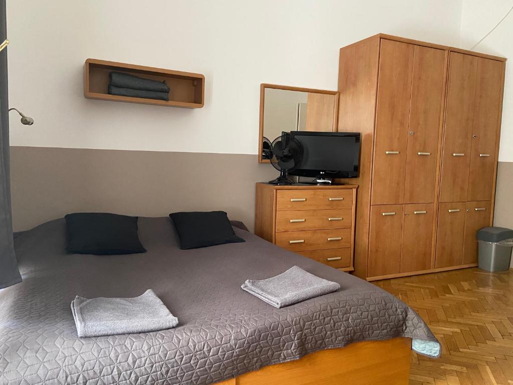 1 dormitorio con 1 cama, vestidor y TV en Guest Rest Studio Apartments, en Budapest