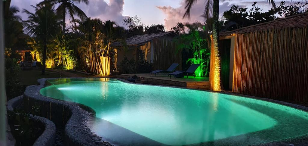 a swimming pool in a backyard at night at Pousada San Antonio Praia in Caraíva