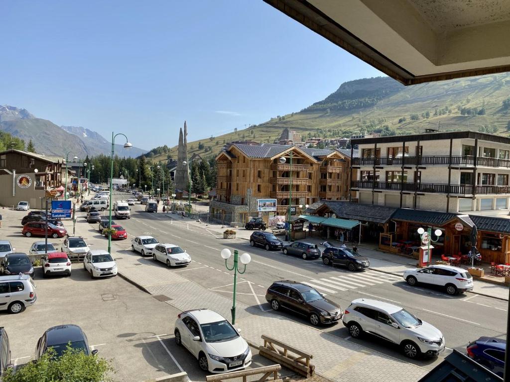 a city with cars parked in a parking lot at Boost Your Immo Les Deux Alpes Kandahar 357 in Les Deux Alpes