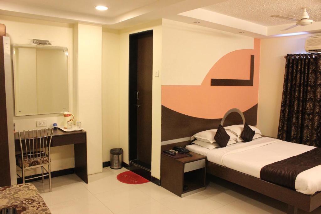 a hotel room with a bed and a desk at Hotel Fortune in Mumbai