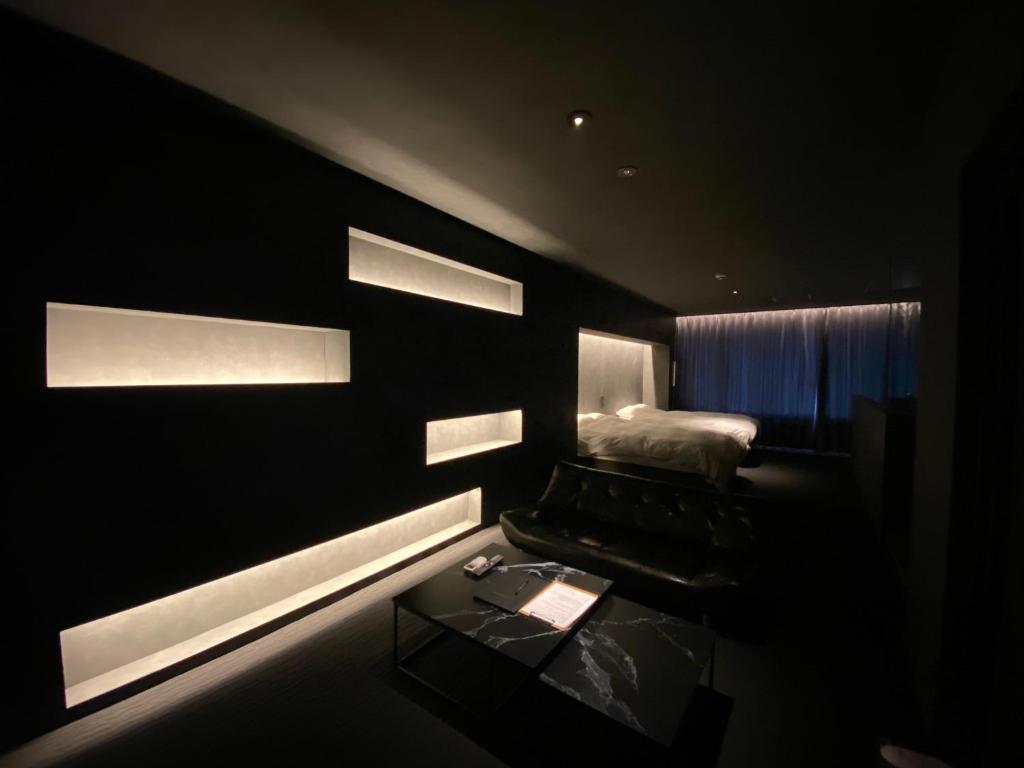 Habitación oscura con cama y mesa. en Randor Residence Hiroshima Suites, en Hiroshima