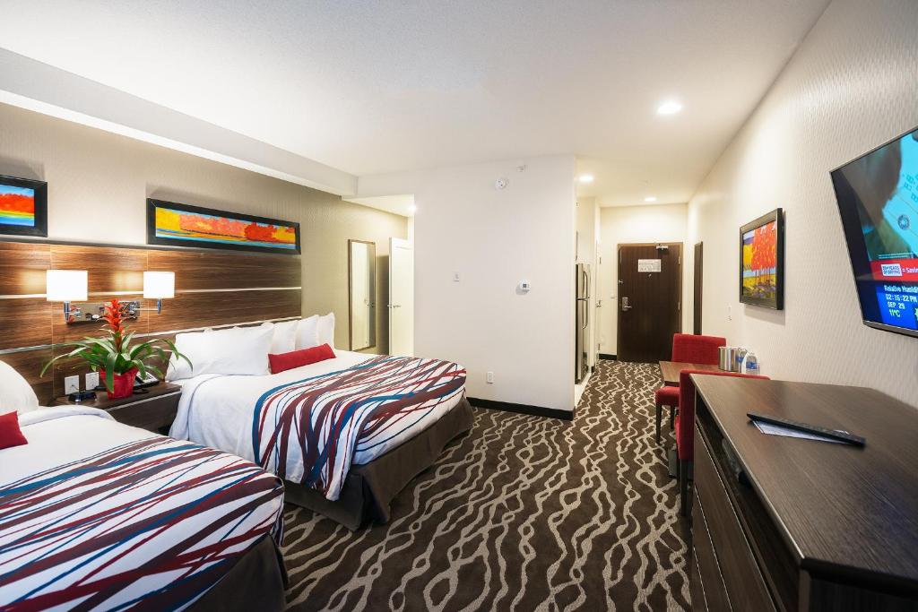 Postel nebo postele na pokoji v ubytování Encore Suites by Service Plus Inns