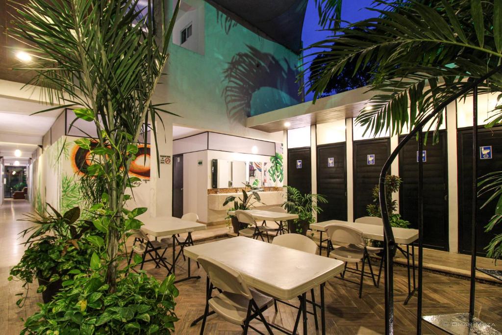 a restaurant with tables and chairs and palm trees at Hostal Gayser in Valladolid