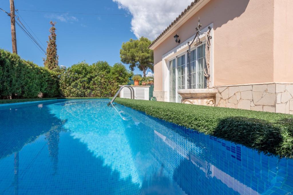 una piscina azul frente a una casa en Villa Son Ferrer en Santa Ponsa
