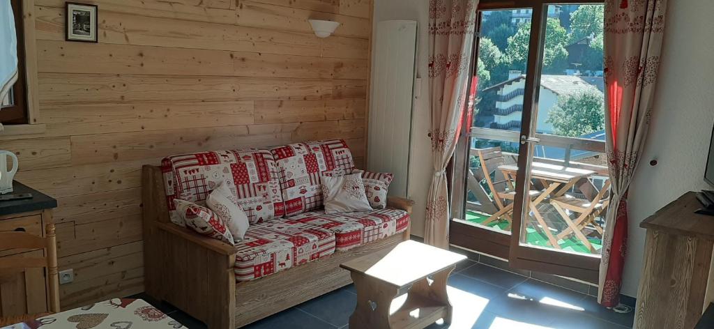 un salon avec un canapé et une fenêtre dans l'établissement Appartement Saint Gervais les Bains, à Saint-Gervais-les-Bains