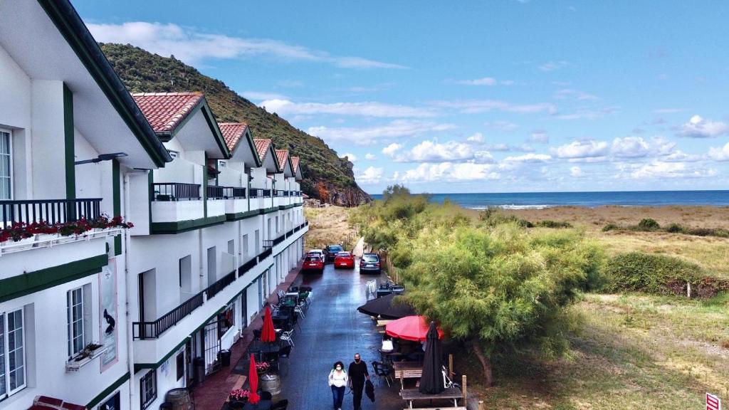 uma vista para uma rua com edifícios e o oceano em Hostal de Berria em Santoña