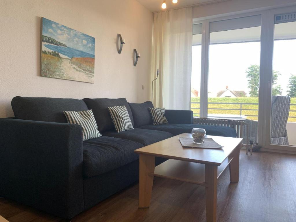 a living room with a blue couch and a coffee table at Haus am Deich Wohnung 2 in Dahme