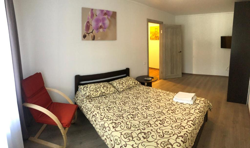 a small bedroom with a bed and a chair at Апартаменты метро Тараса Шевченко in Kyiv